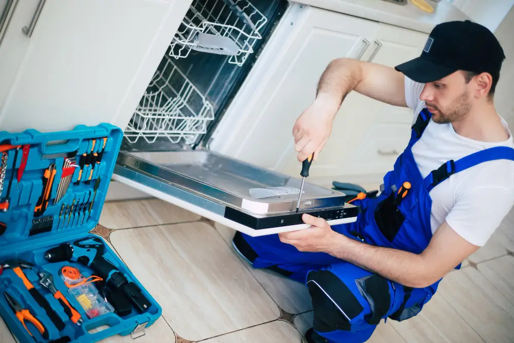 Near Appliance technician repairing a dishwasher door in Vancouve