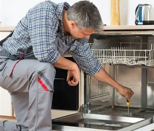 Technician inspecting a residential dishwasher in Vancouver, BC – illustrating our expert dishwasher repair services.