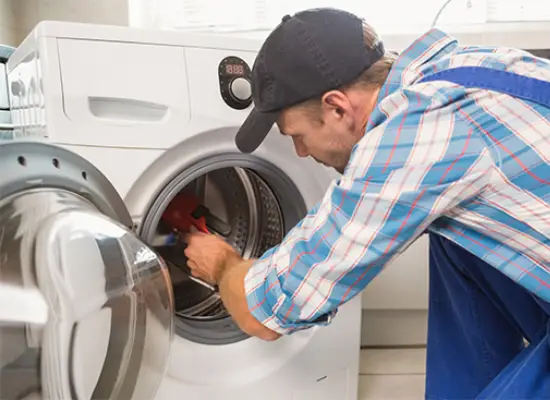 Technician repairing a clothes dryer in a home in Vancouver, BC – part of our expert dryer repair services.