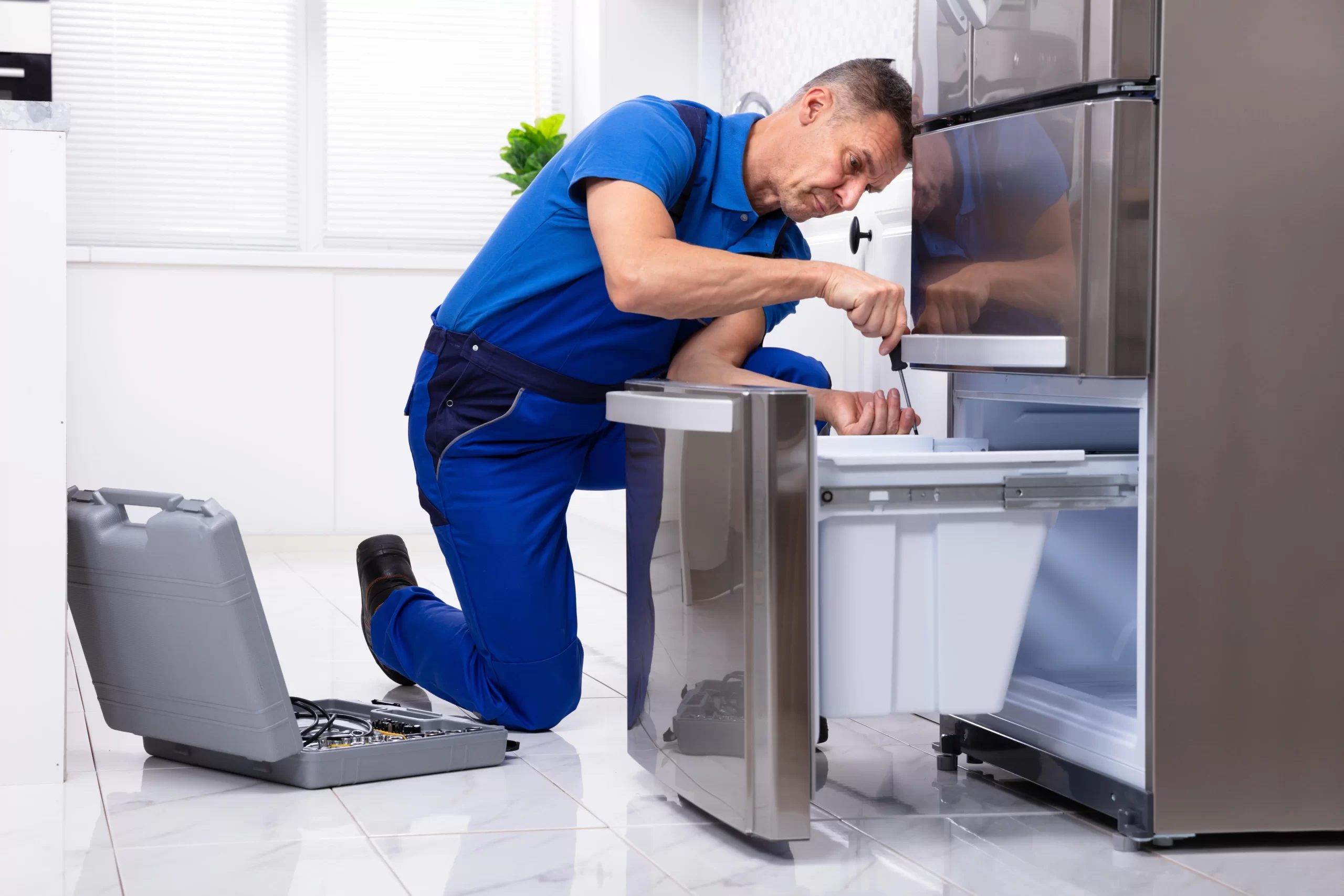 Near Appliance serviceman repairing a refrigerator drawer in Vancouver.